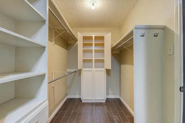 a view of walk in closet with wooden floor