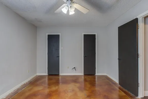 an empty room with closet and a chandelier fan