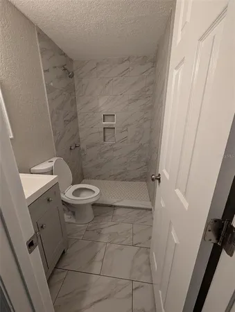 a bathroom with a toilet and a shower