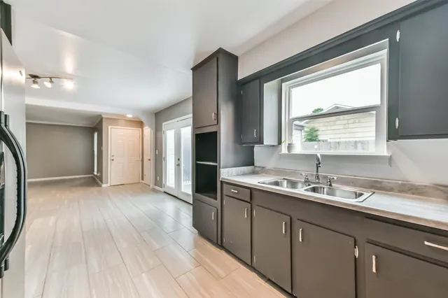 a kitchen with a sink window and a refrigerator