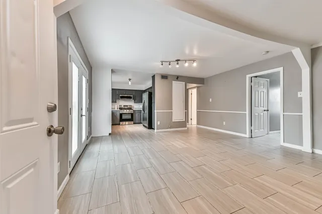 wooden floor in an empty room with a kitchen