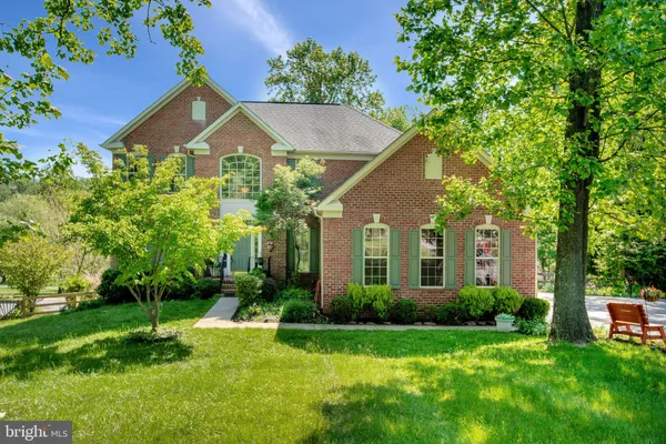 a kitchen with stainless steel appliances granite countertop a table chairs sink refrigerator and cabinets