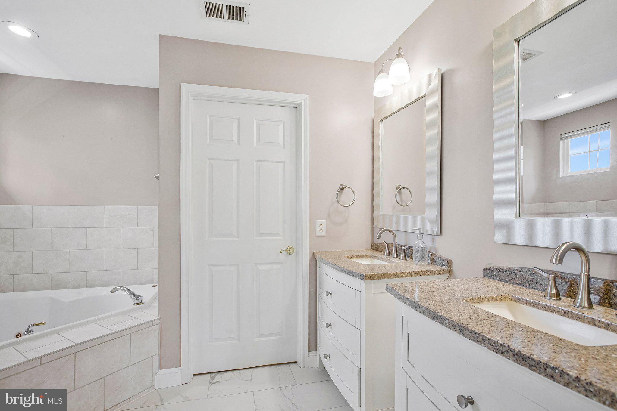 13215 Falls Road Cockeysville, MD 21030 - Photo 13 of 40 a bathroom with a granite countertop sink mirror and bathtub