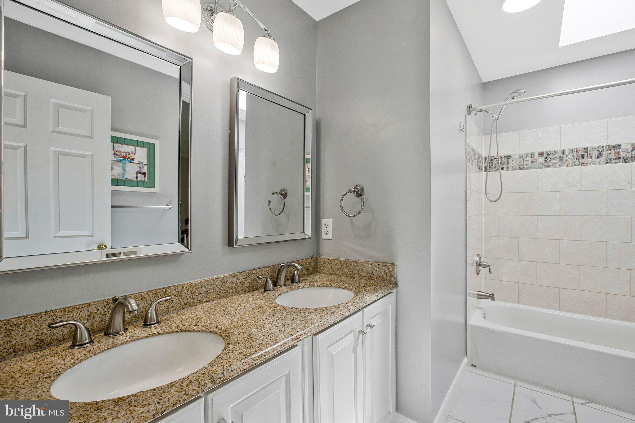 13215 Falls Road Cockeysville, MD 21030 - Photo 18 of 40 a bathroom with a granite countertop sink mirror and a bathtub