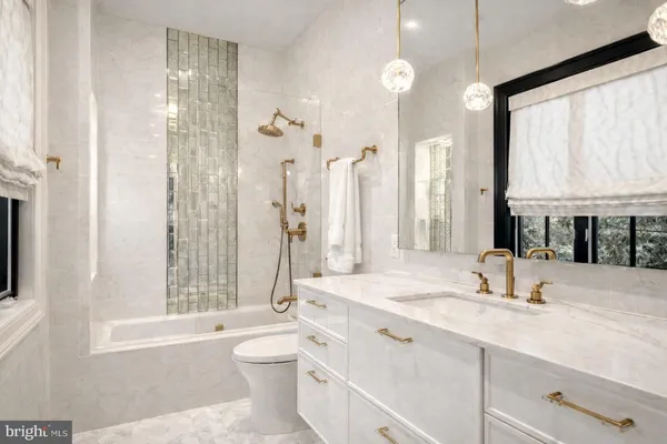 a bathroom with a double vanity sink toilet mirror and bathtub