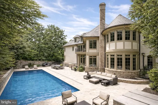 a view of a white house with swimming pool and sitting area