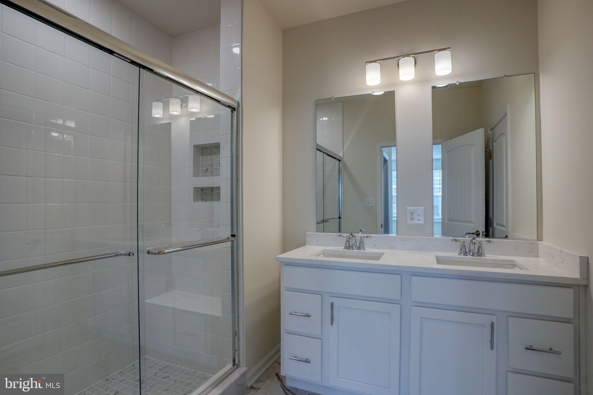 33828 Coldstream Street Frankford, DE 19945 - Photo 23 of 48 a bathroom with a double vanity sink mirror and shower