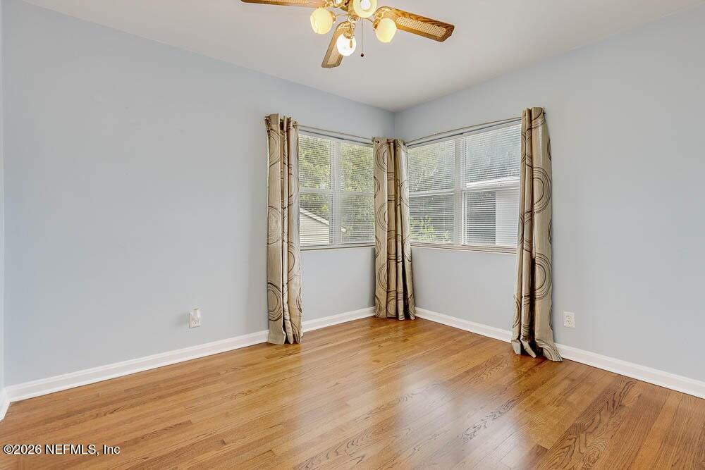 773 Wren Road Jacksonville, FL 32216 - Photo 11 of 17 an empty room with wooden floor chandelier fan and windows