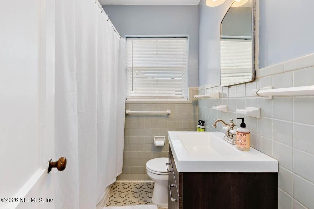 773 Wren Road Jacksonville, FL 32216 - Photo 12 of 17 a bathroom with a sink a toilet and a mirror