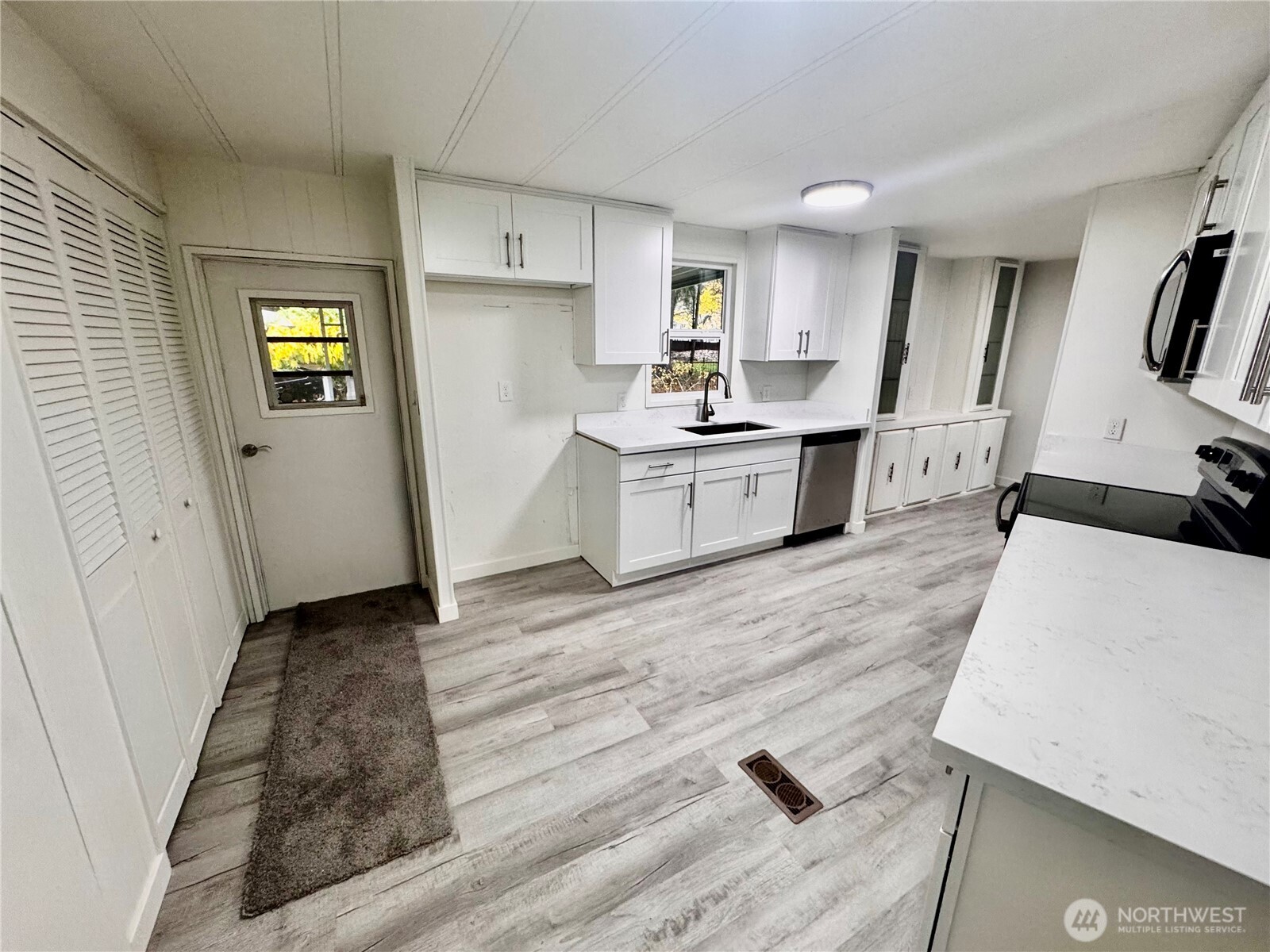 18425 Northeast 95th Street, Unit 76 Redmond, WA 98052 - Photo 9 of 20 a large white kitchen with wooden floor