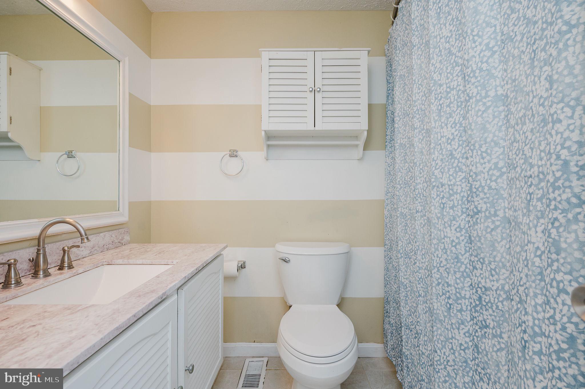 2601 Merrick Way Abingdon, MD 21009 - Photo 31 of 59 a bathroom with a granite countertop toilet a sink a mirror and a window