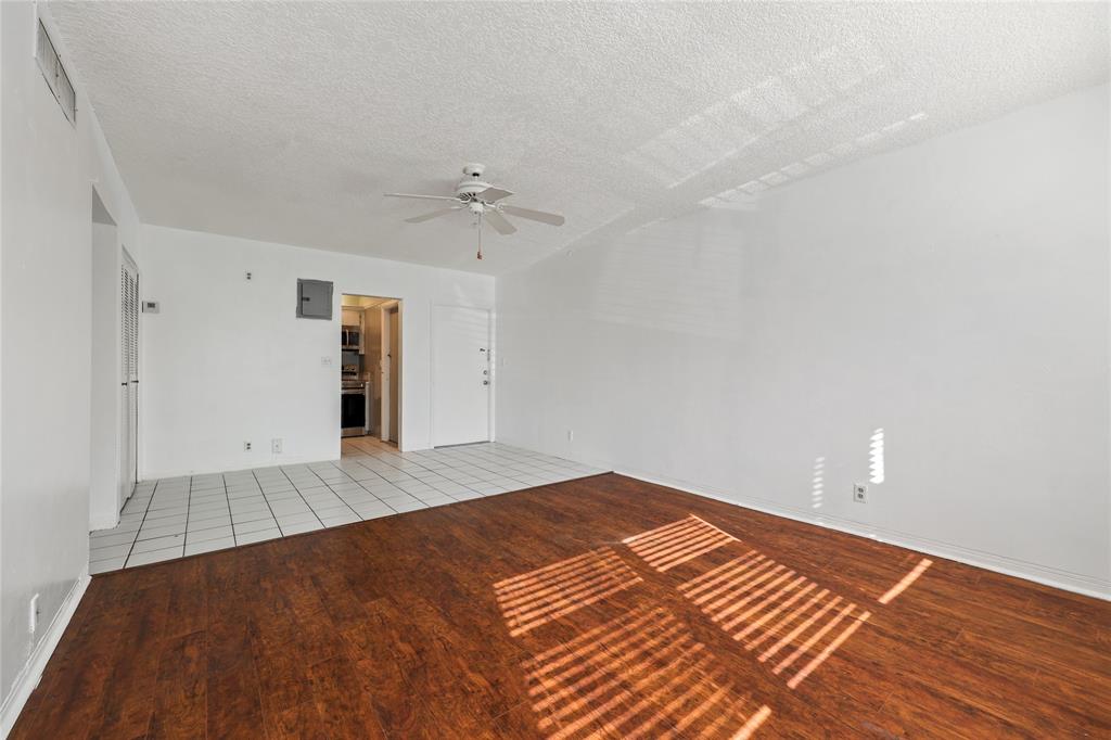 280 South Cypress Road, Unit 306 Pompano Beach, FL 33060 - Photo 5 of 17 a view of an empty room with wooden floor and a ceiling fan
