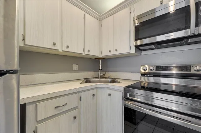 a kitchen with stainless steel appliances granite countertop a sink and a microwave