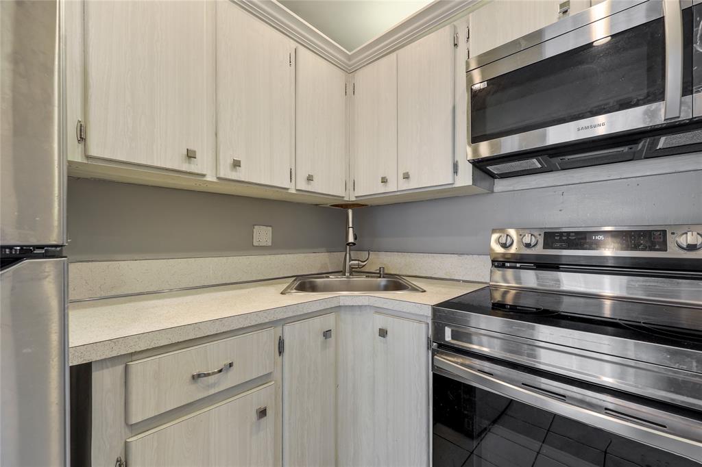280 South Cypress Road, Unit 306 Pompano Beach, FL 33060 - Photo 6 of 17 a kitchen with stainless steel appliances granite countertop a sink and a microwave