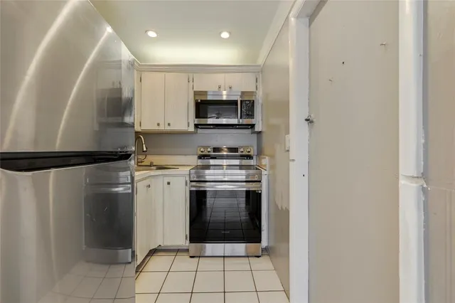 a kitchen with a refrigerator and a stove top oven