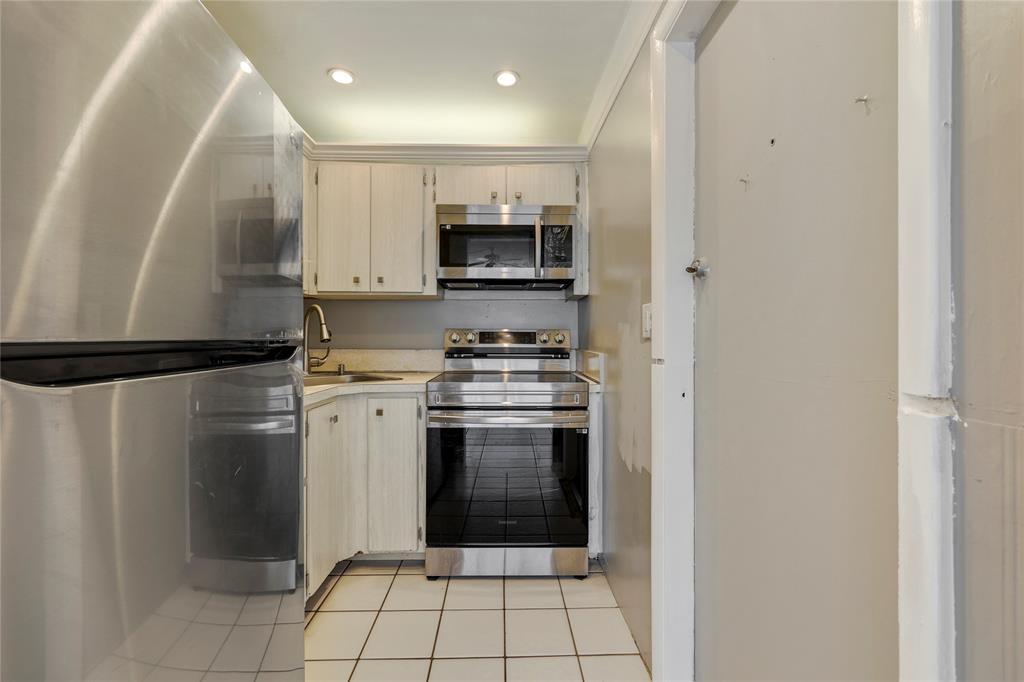 280 South Cypress Road, Unit 306 Pompano Beach, FL 33060 - Photo 7 of 17 a kitchen with a refrigerator and a stove top oven
