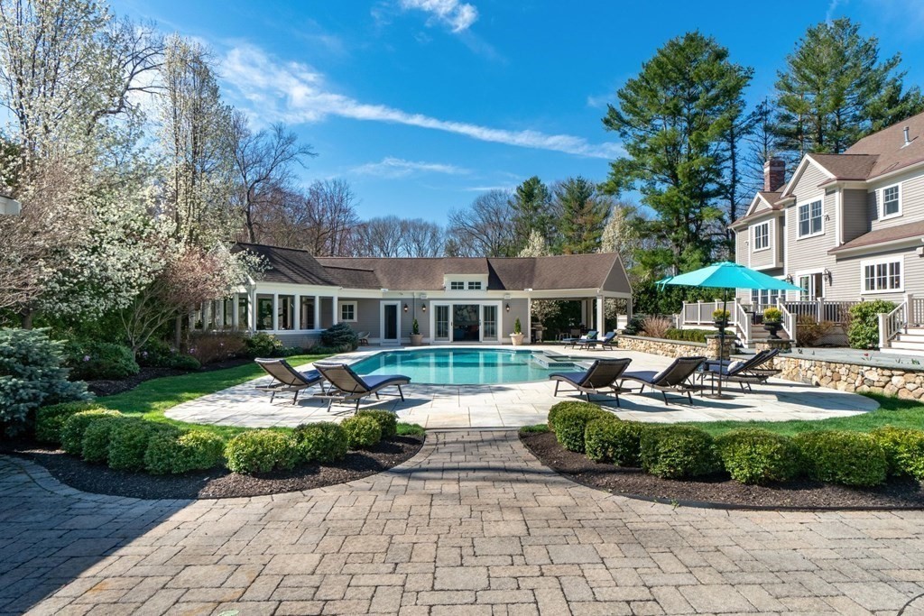 99 Country Way Needham, MA 02492 - Photo 5 of 42 a front view of a house with garden swimming pool and outdoor seating