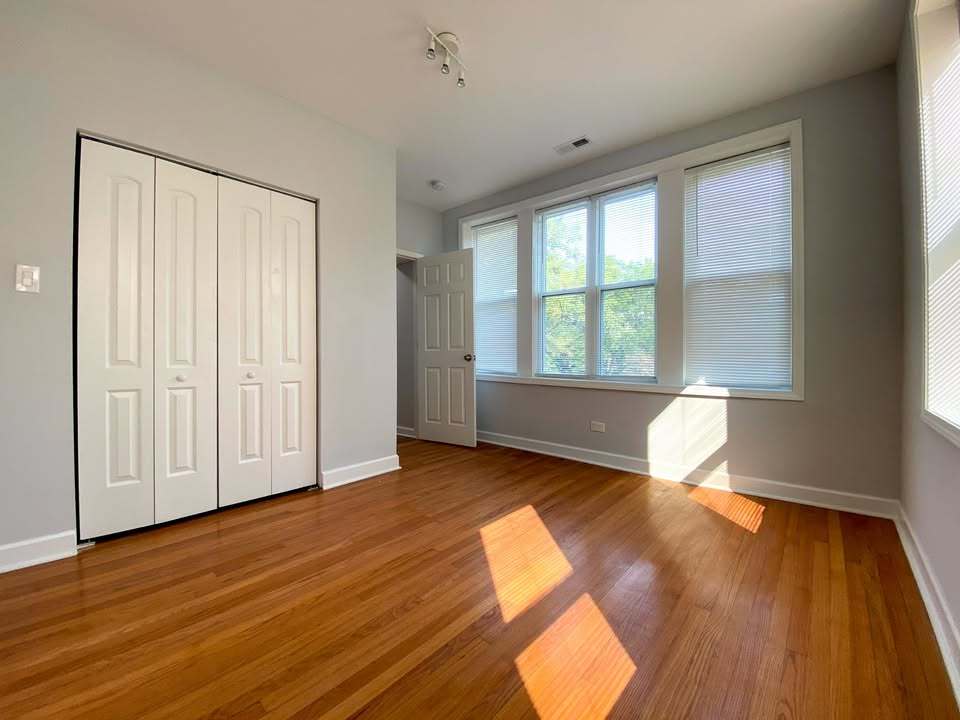 619 East Groveland Park, Unit 2W Chicago, IL 60616 - Photo 11 of 17 an empty room with wooden floor and windows