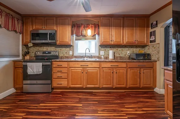 a kitchen with stainless steel appliances granite countertop a stove a sink and a microwave