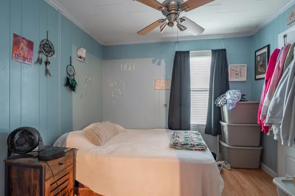 a bedroom with a bed and wooden floor