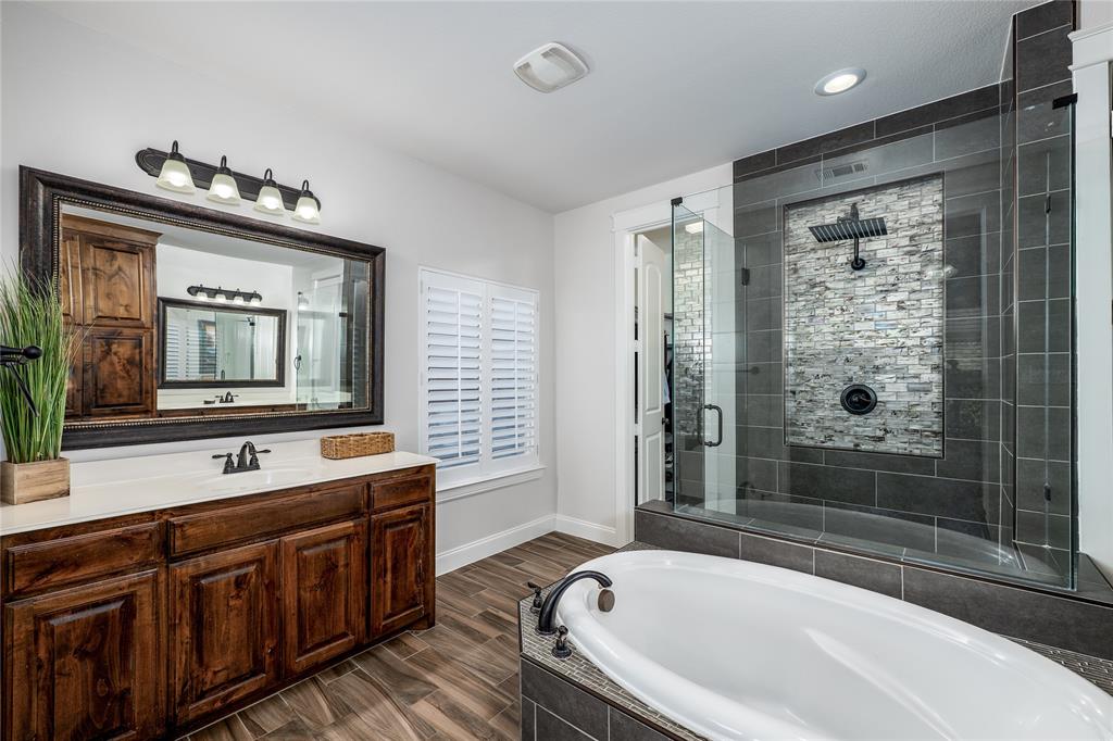 309 Bachman Creek Drive McKinney, TX 75072 - Photo 15 of 37 a bathroom with a bathtub a sink and a large mirror