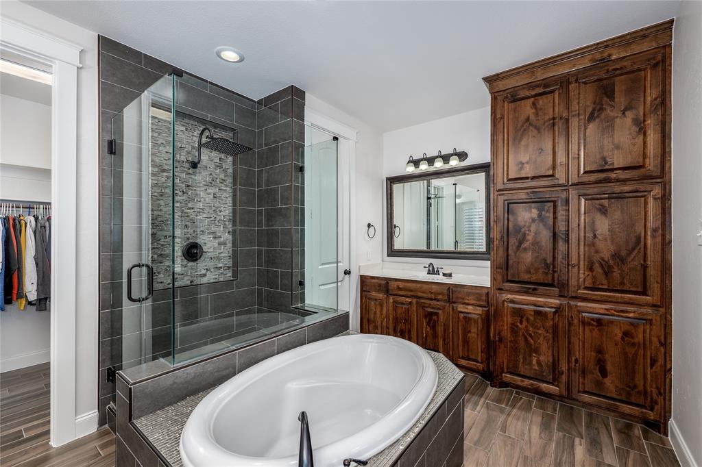 309 Bachman Creek Drive McKinney, TX 75072 - Photo 16 of 37 a bathroom with a tub a sink and mirror