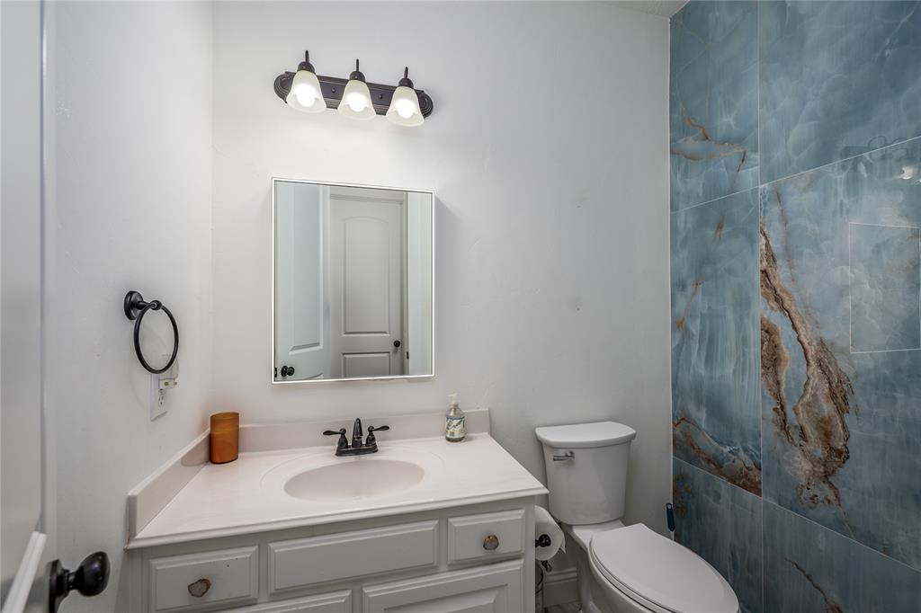 309 Bachman Creek Drive McKinney, TX 75072 - Photo 18 of 37 a bathroom with a sink a toilet and mirror