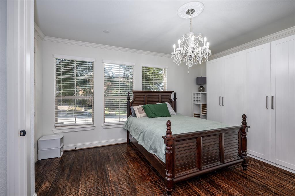 309 Bachman Creek Drive McKinney, TX 75072 - Photo 19 of 37 a bedroom with a bed and a chandelier