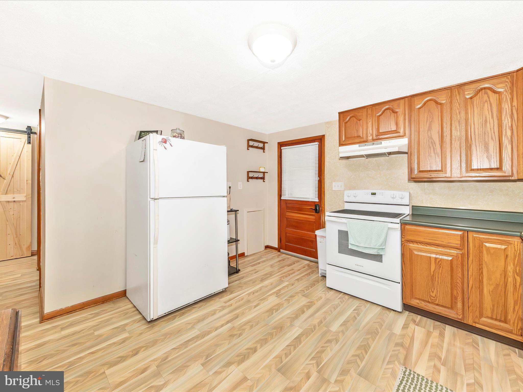 14021 Broadfording Church Road Hagerstown, MD 21740 - Photo 12 of 46 a kitchen with granite countertop a refrigerator and a stove top oven