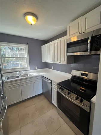 a kitchen with a stove cabinets and a window