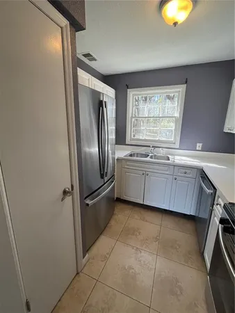 a kitchen with a refrigerator a sink and a window