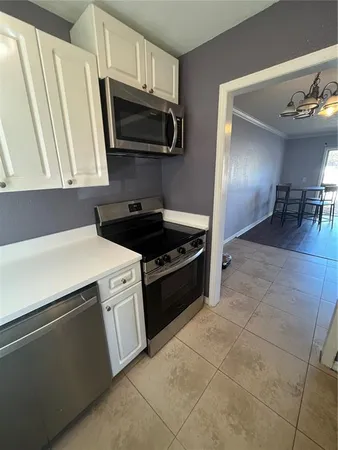 a kitchen with stainless steel appliances a sink a stove a microwave and cabinets