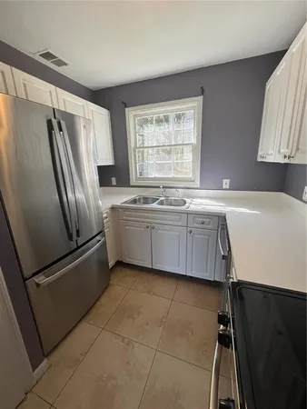 a kitchen with stainless steel appliances a sink a stove a refrigerator and cabinets