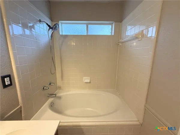 a white bath tub sitting next to a shower