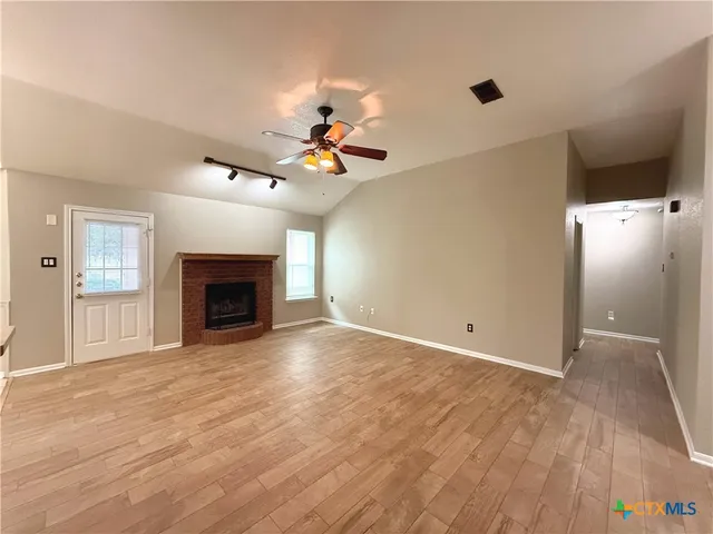 a view of an empty room with a fireplace and a window