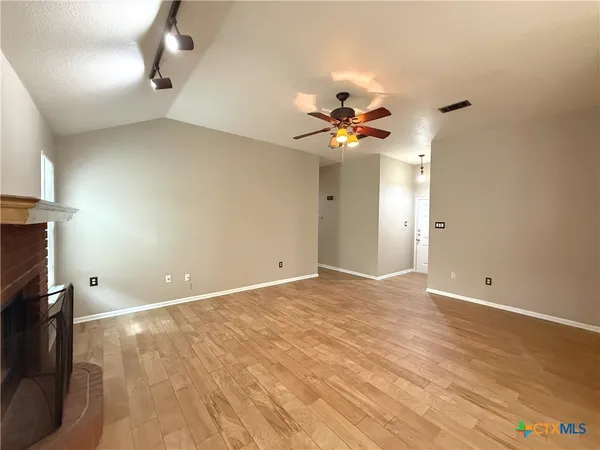 a view of an empty room with a chandelier fan