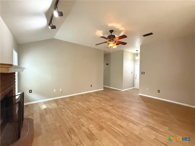 a view of an empty room with a chandelier fan