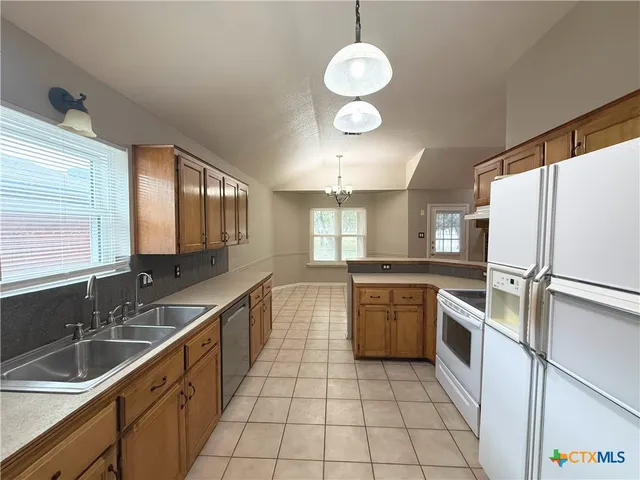 a kitchen with a sink refrigerator and cabinets
