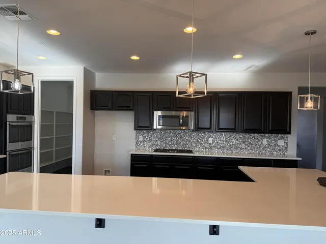 a large kitchen with kitchen island a sink stainless steel appliances and a counter top