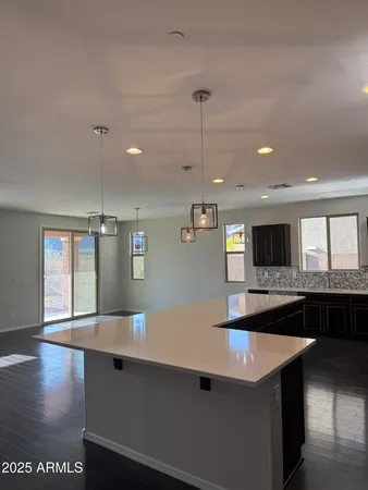 a large kitchen with stainless steel appliances a large counter top a stove a sink and a refrigerator