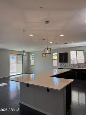 a large kitchen with stainless steel appliances a large counter top a stove a sink and a refrigerator