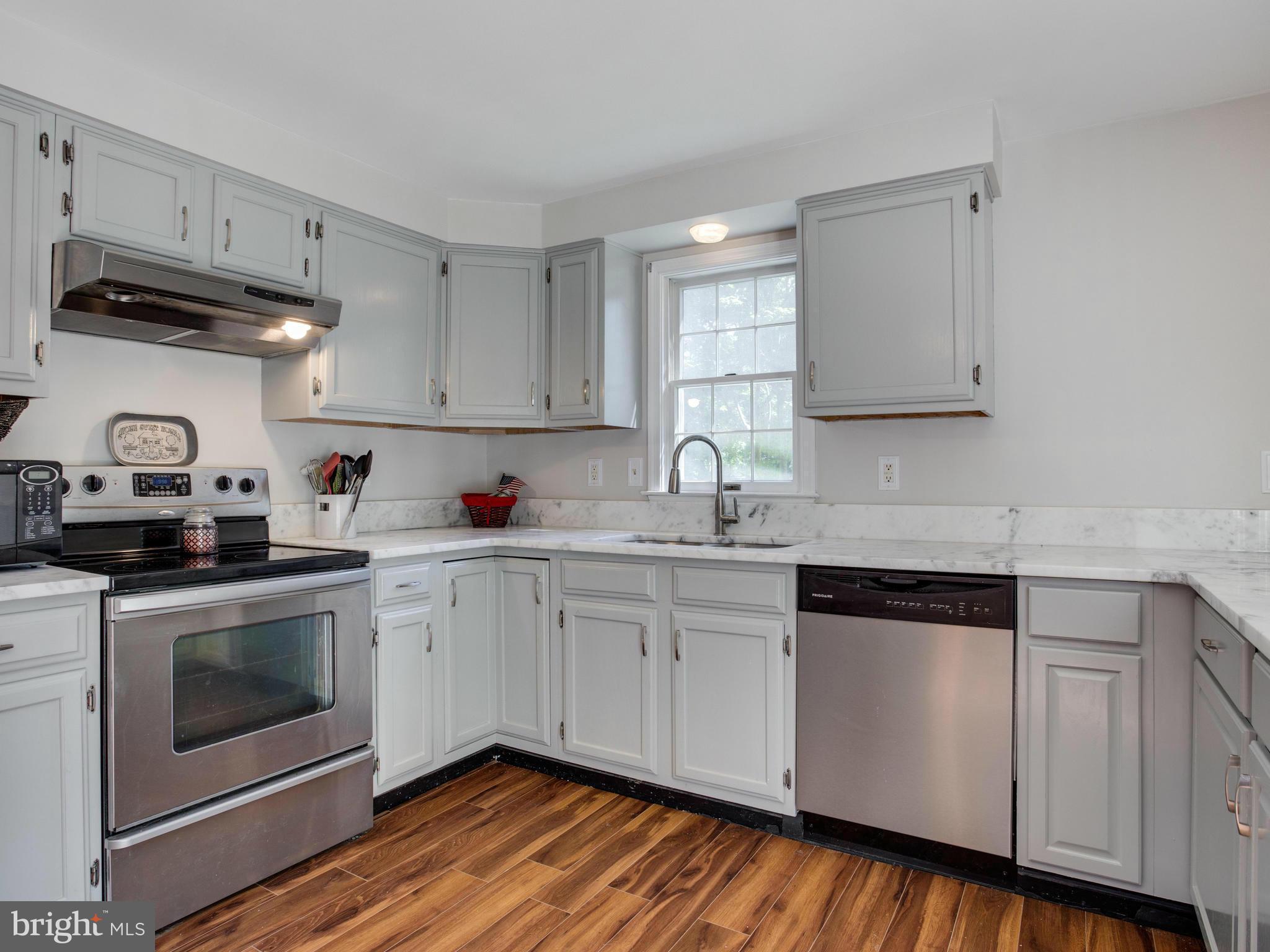 12708 Olivet Road Lusby, MD 20657 - Photo 2 of 22 a kitchen with granite countertop white cabinets and white appliances