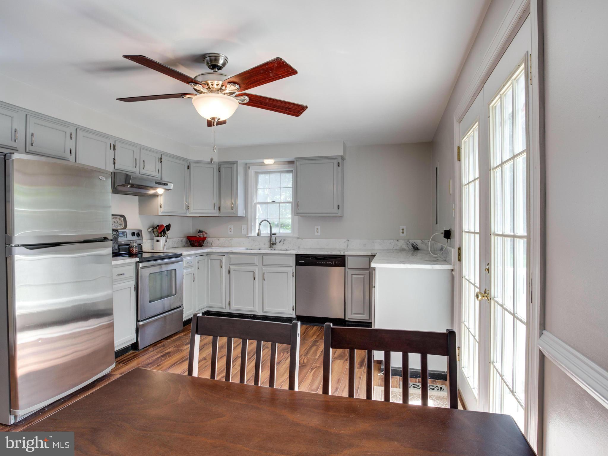 12708 Olivet Road Lusby, MD 20657 - Photo 4 of 22 a kitchen with white cabinets and stainless steel appliances