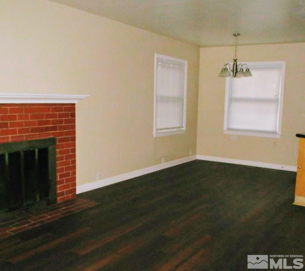 983 Lester Avenue Reno, NV 89502 - Photo 5 of 7 an empty room with wooden floor windows and fireplace