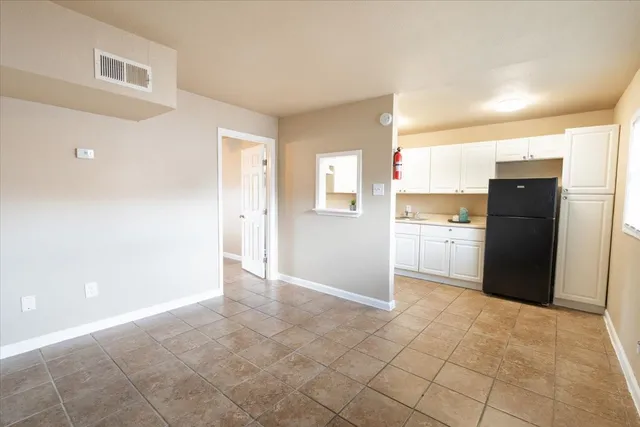 a view of a kitchen with refrigerator and cabinet