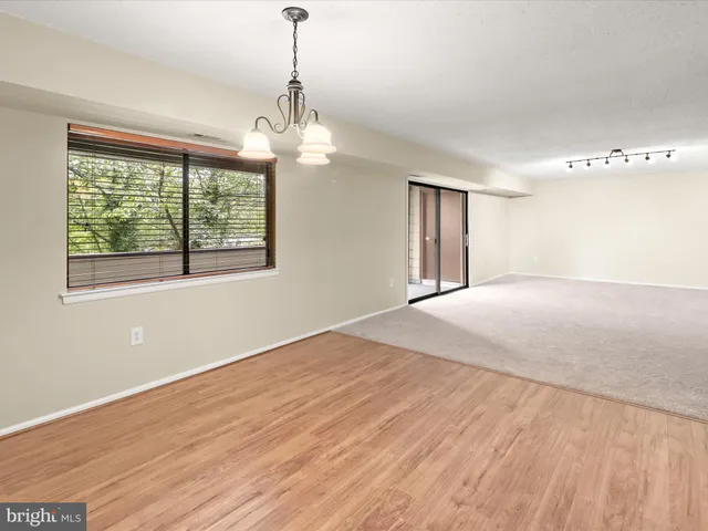 a spacious bedroom with a large bed and a chandelier