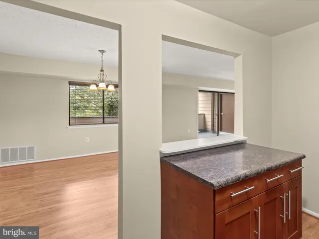 a view of a room with wooden floor electronic appliances and window