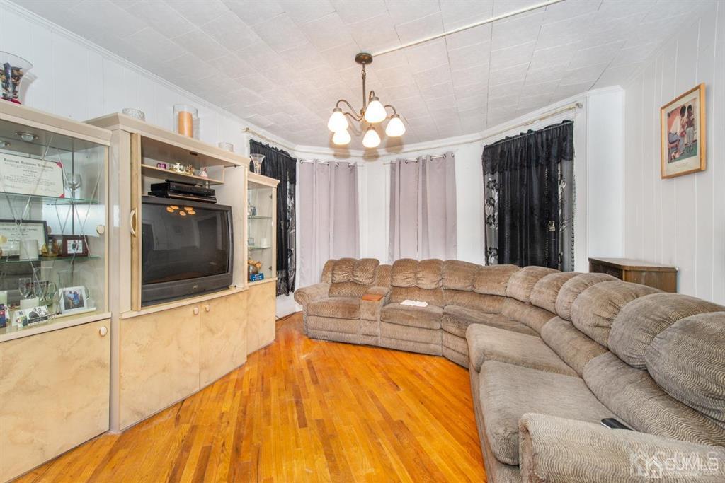 3 Ricord Street Newark, NJ 07106 - Photo 8 of 24 a spacious bedroom with a bed and a chandelier