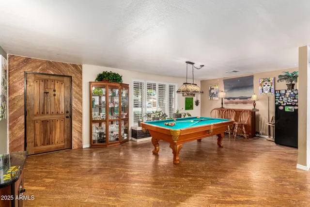 a living room with furniture and a pool table