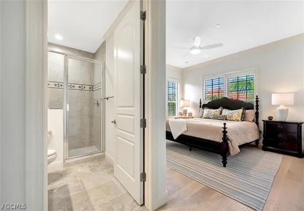 a bedroom with a bed a couch and a chandelier